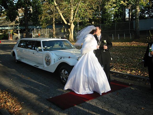 bride and groom by the limo